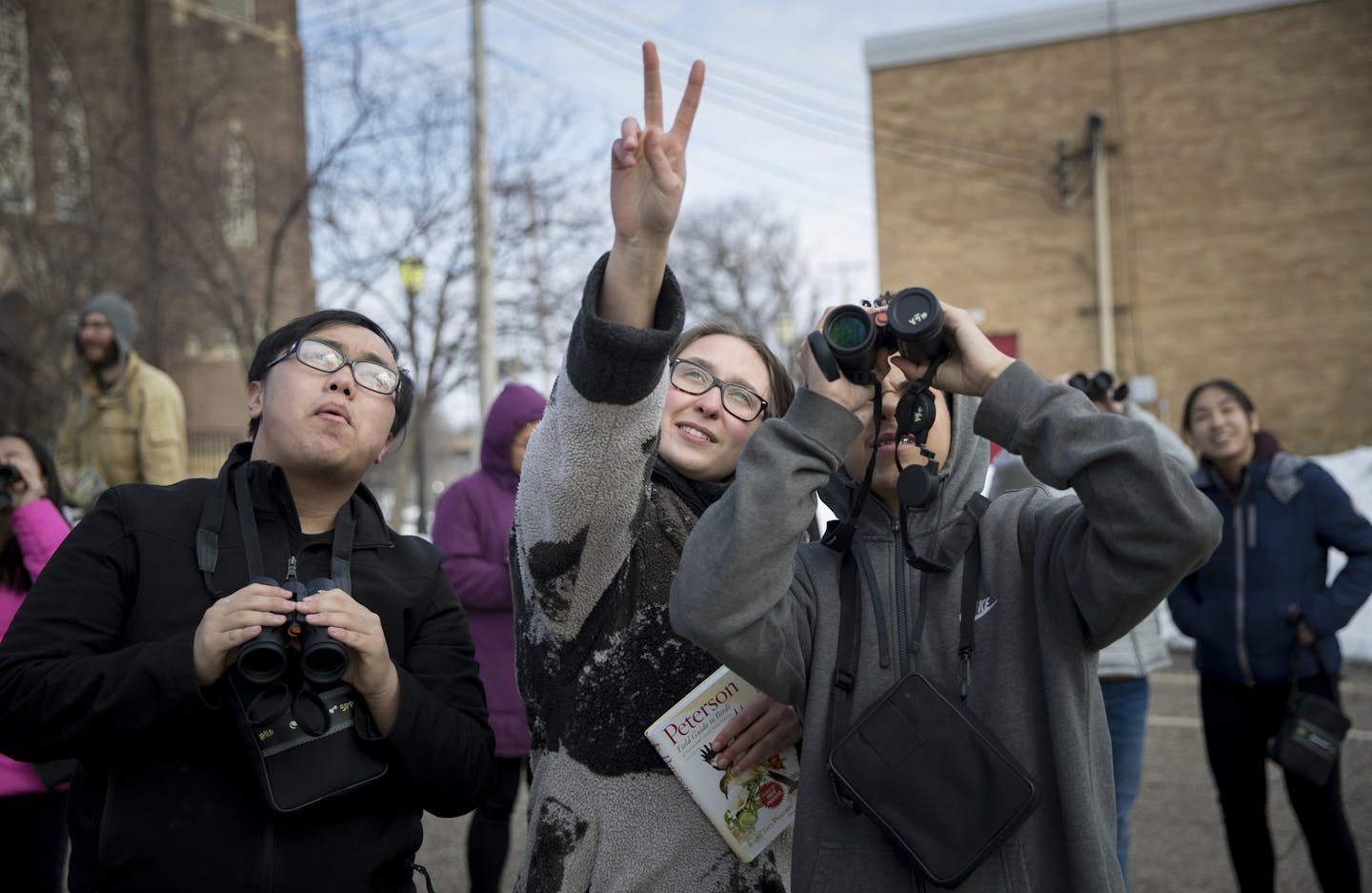 Macalester College student Emma Wise pointed out birds for Sai Chang, 16, left, and Marquise Tatum, 15, during an Urban Roots program on April 10. The nonprofit gives young people the opportunity to work in urban gardens.