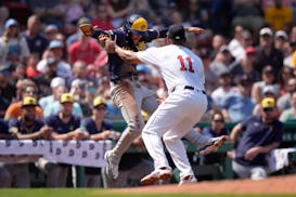 Brewers baserunner Brice Turang, left, is tagged out in a rundown by Red Sox third baseman Rafael Devers on Sunday in Boston.