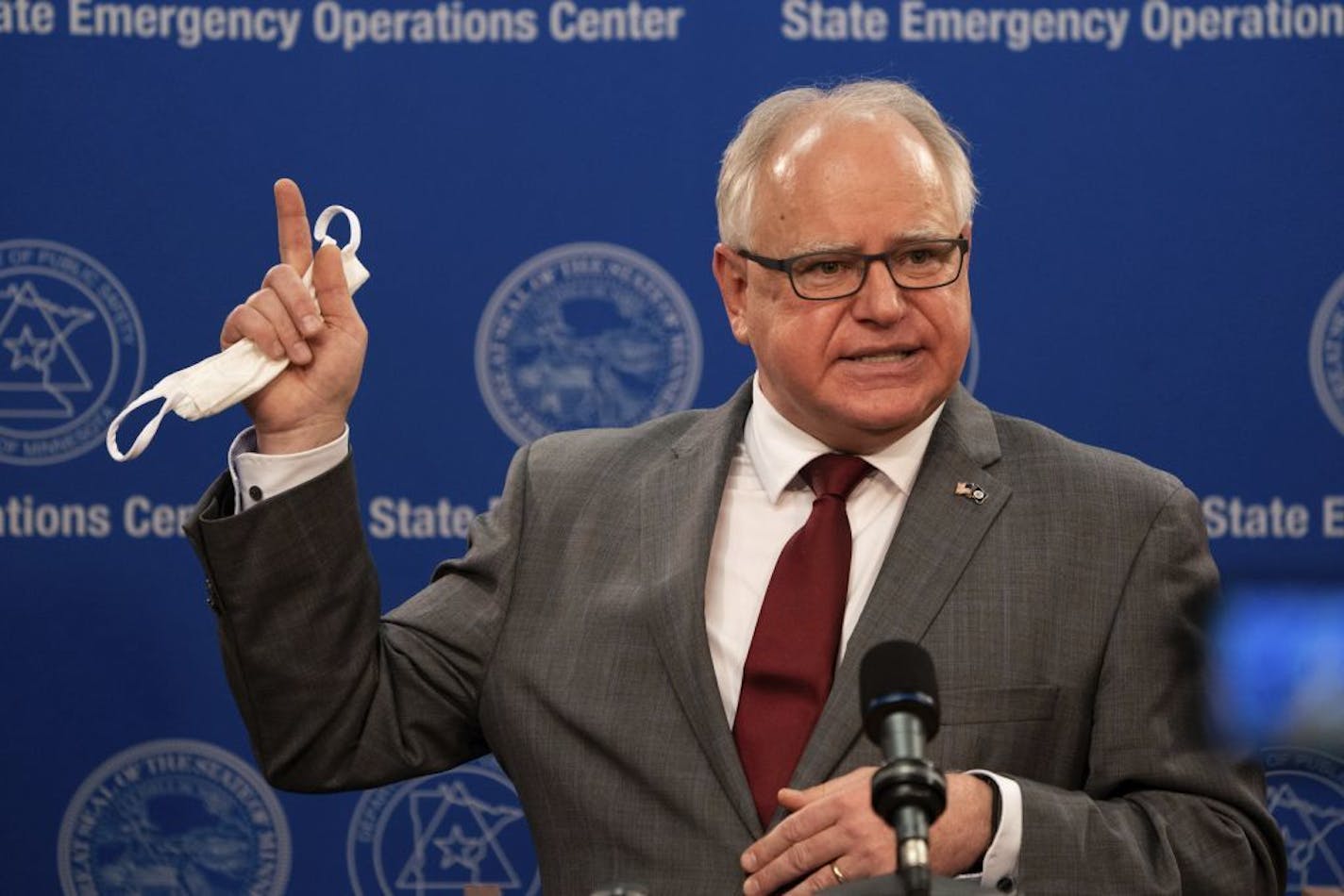 Minnesota Gov. Tim Walz answered questions about extending his stay-at-home order while holding a face mask Thursday in St. Paul.