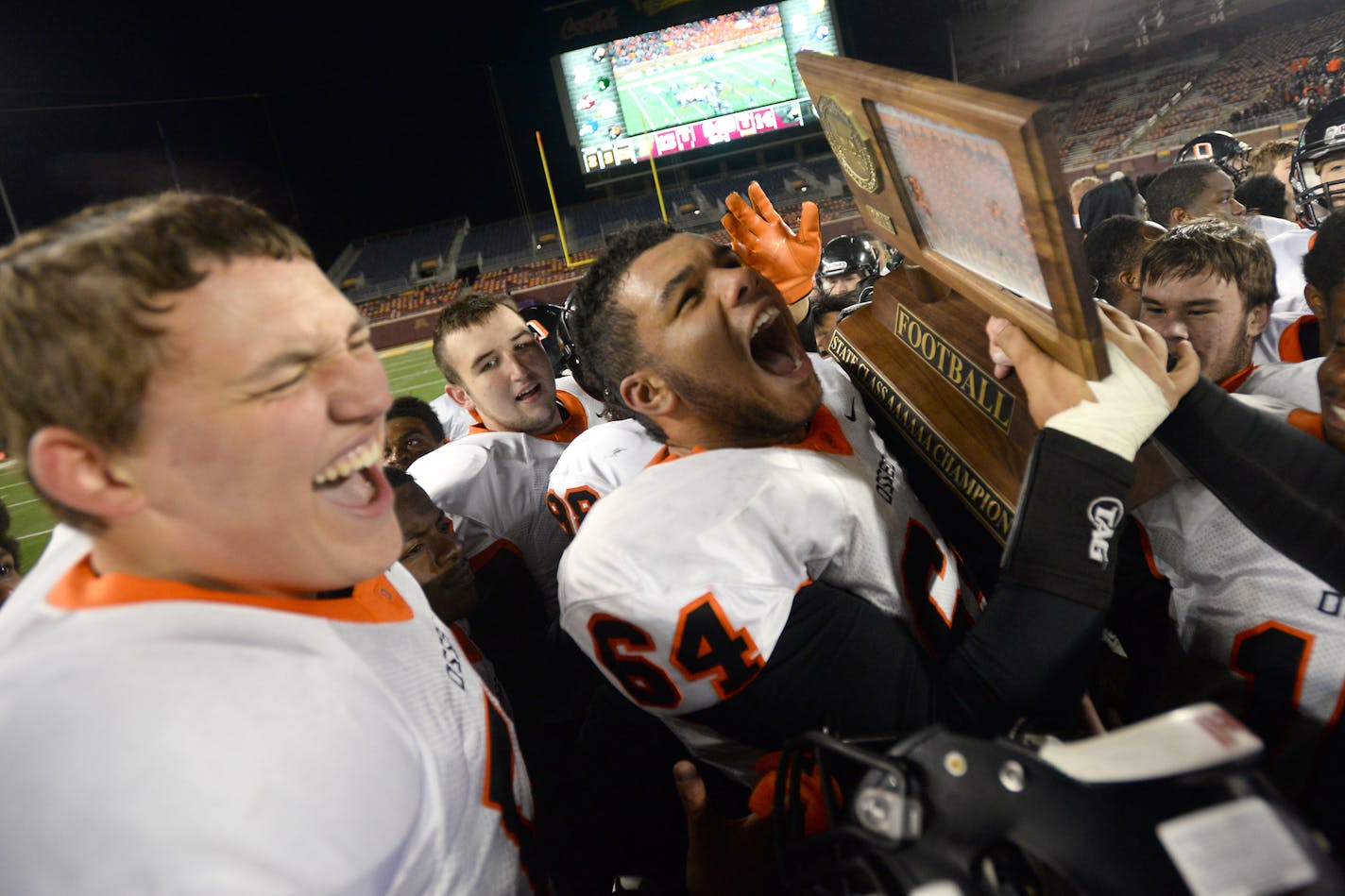 Osseo offensive lineman Nehemiah Beckstrand (64) celebrated with the team's championship trophy after winning the 6A title against East Ridge. ] (AARON LAVINSKY/STAR TRIBUNE) aaron.lavinsky@startribune.com Osseo played East Ridge in the Class 6A championship game on Friday, Nov. 13, 2015 at TCF Bank Stadium.