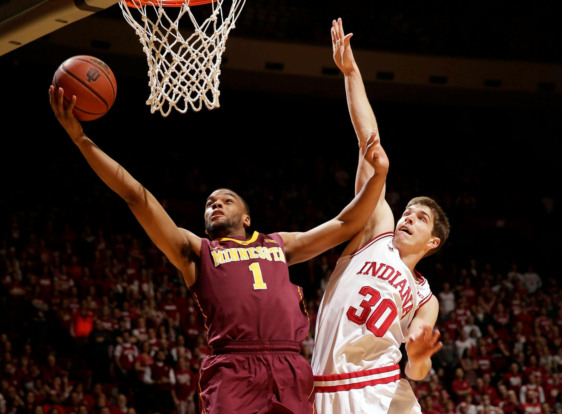 Minnesota guard Andre Hollins (1) shoots in front of Indiana forward Collin Hartman (30) during the first half of an NCAA college basketball game, Sunday, Feb. 15, 2015, in Bloomington, Ind. (AP Photo/AJ Mast)