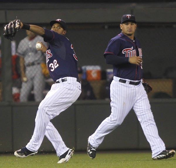 Twins center fielder Aaron Hicks double-clutched before making the throw home in the 10th inning after getting bumped by left fielder Oswaldo Arcia. T