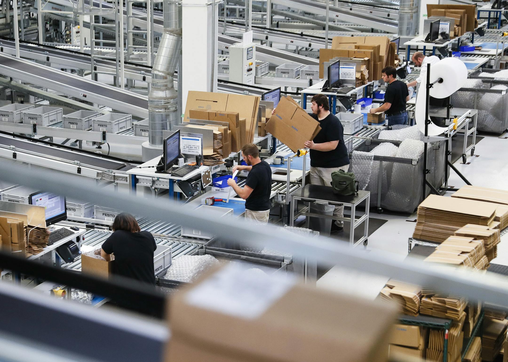 In this Wednesday, May 17, 2017 photo, workers operate packaging stations that feed into an expansive system of conveyor belts connecting separate factory areas at a Festo distribution center in Mason, Ohio. "None of these technologies work without the people," said Carolin McCaffrey, head of Learning Center Midwest for Festo Didactics, which last year launched two-year apprenticeship programs in mechatronics. Skip Johnson, a trainer in STIHL's apprenticeship program, said the key is getting bri