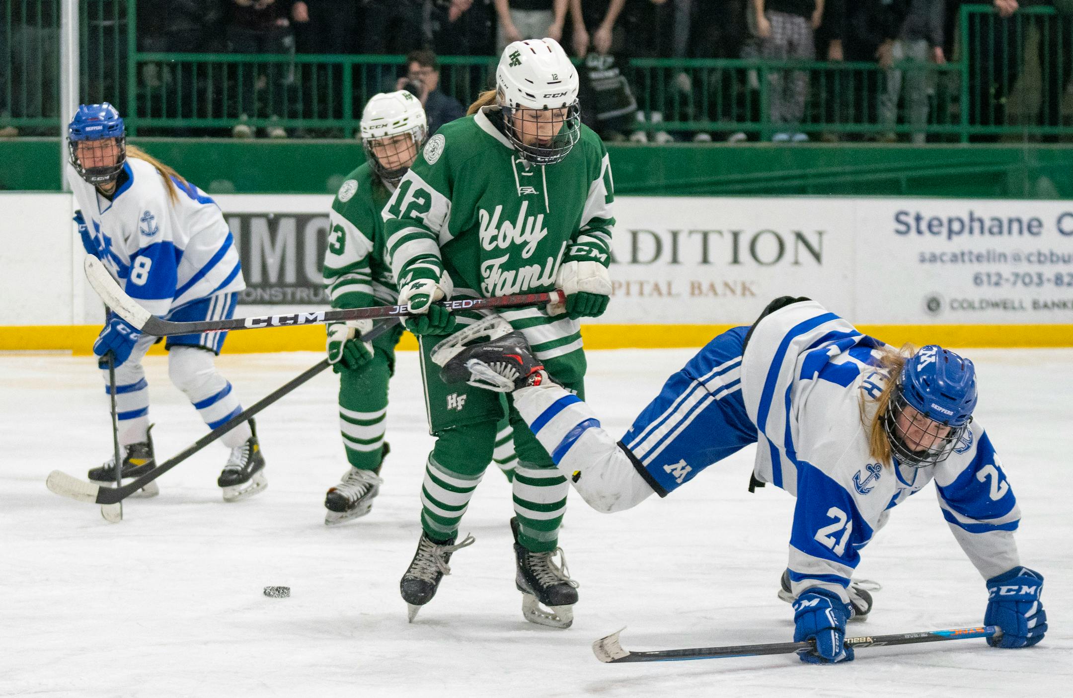 Minnetonka forward Senja Leeper (21) falls in front of Holy Family forward Haley Box (12) during the first period.