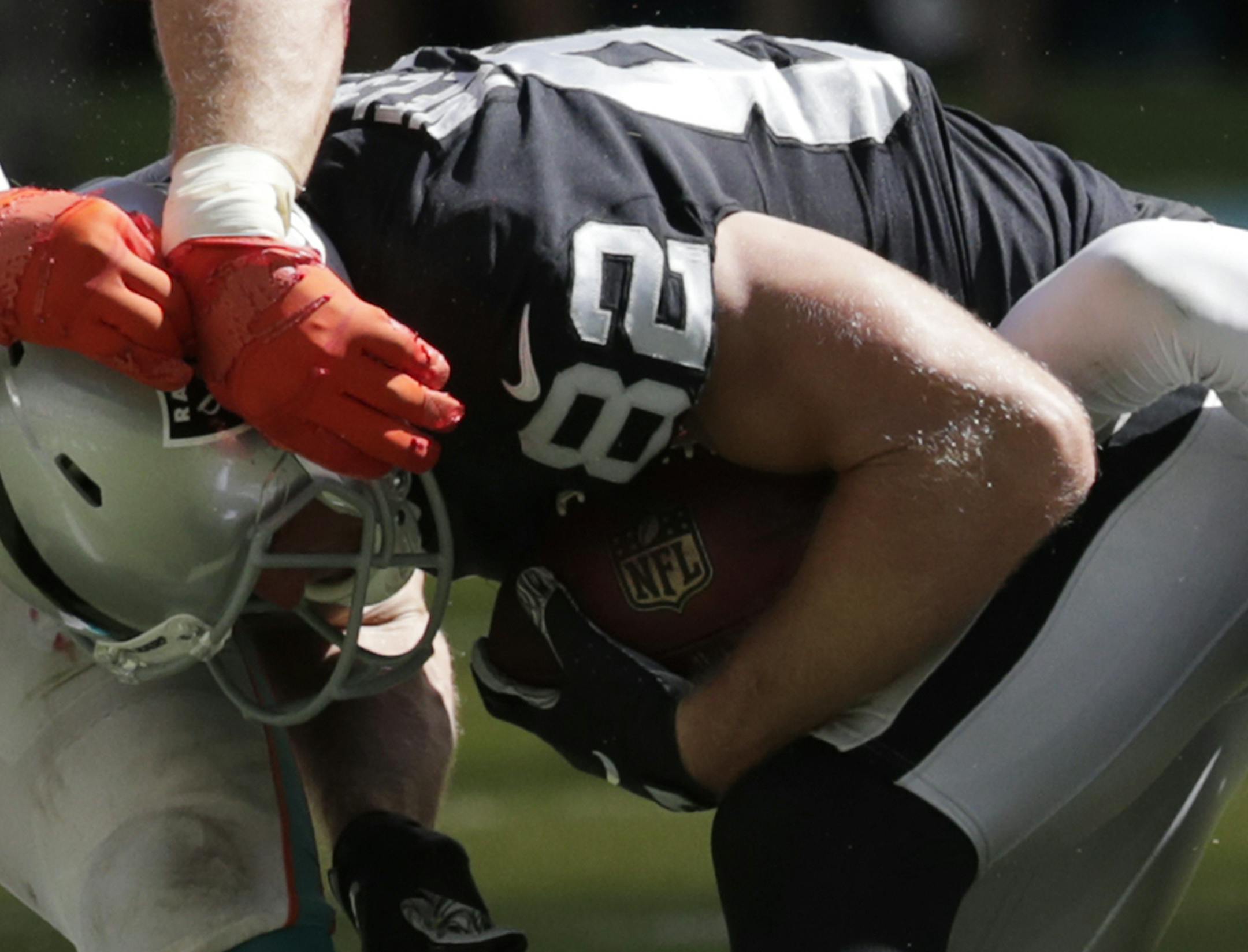 Miami Dolphins linebacker Kiko Alonso, left, and cornerback Bobby McCain, right, take down Oakland Raiders wide receiver Jordy Nelson (82) during the second half of an NFL football game, Sunday, Sept. 23, 2018, in Miami Gardens, Fla. (AP Photo/Lynne Sladky)