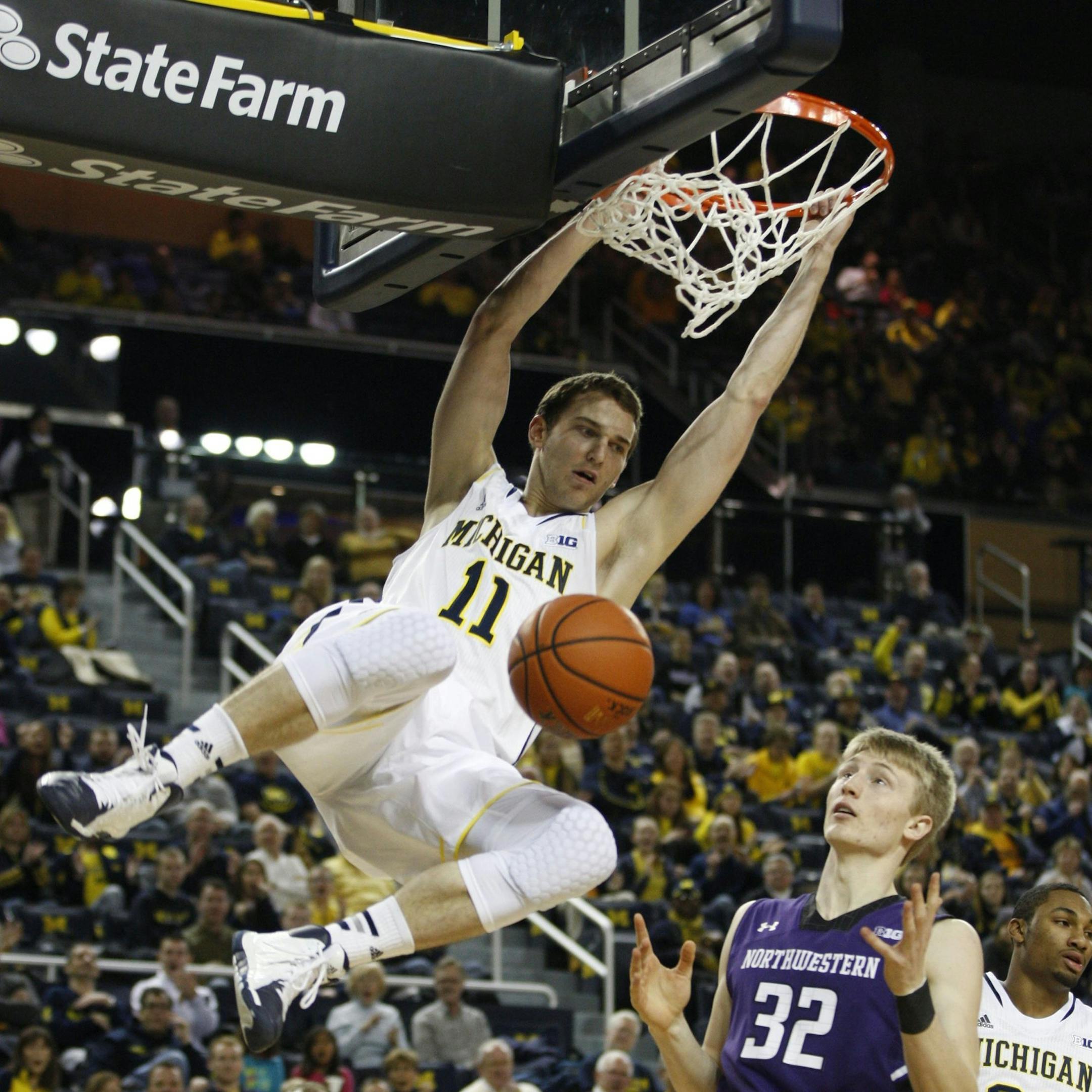 Michigan's Nik Stauskas finishes a dunk off the lob pass from Spike Albrecht during the first half over Northwestern's Nathan Taphorn, bottom right, in Ann Arbor, Mich., on Sunday, Jan. 5, 2014. The Michigan Wolverines defeated the Northwestern Wildcats, 74-51. (Julian H. Gonzalez/Detroit Free Press/MCT) ORG XMIT: 1147507