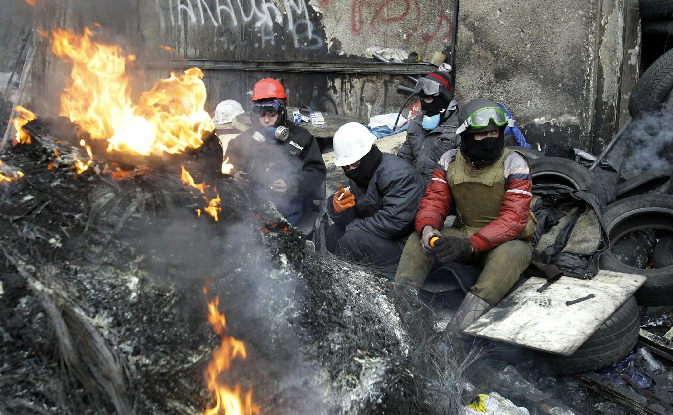 Protesters on Tuesday rested behind a barricade in front of riot police in Kiev, Ukraine. The government’s concessions are unlikely to defuse the violence that has grown.