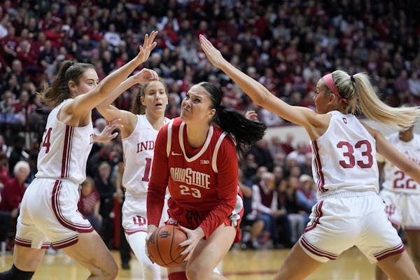 Ohio State's Rebeka Mikulasikova (23) goes to the basket against Indiana's Mackenzie Holmes (54) and Sydney Parrish (33) during the first half of an N