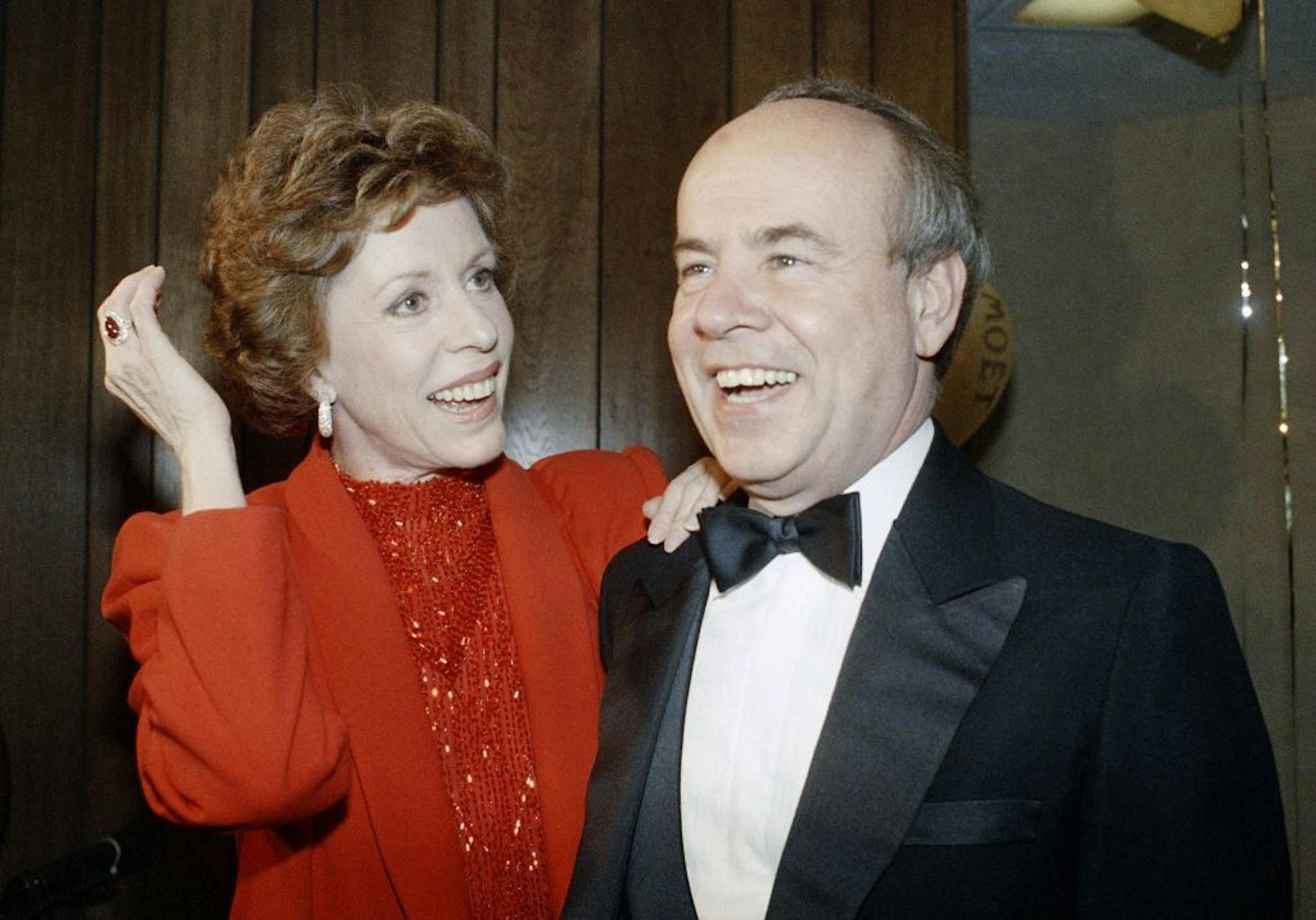 FILE - In this April 26, 1986 file photo, Carol Burnett, left, and veteran comrade in comedy Tim Conway laugh during a gala birthday party for Burnett in Los Angeles. Conway, the impish second banana to Burnett who won four Emmy Awards on her TV variety show, starred aboard "McHale's Navy" and later created a very short character named Dorf, has died. He was 85. Conway died Tuesday morning, May 14, 2019, in a Los Angeles care facility after a long illness, according to Howard Bragman, who heads