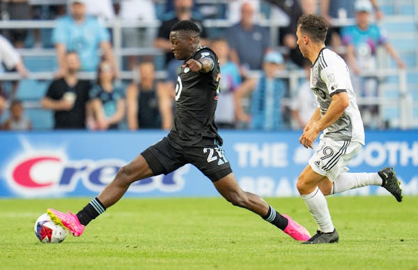 Minnesota United forward Bongokuhle Hlongwane (21) kicks the ball away from Toronto FC midfielder Kobe Franklin (19) in the first half Saturday, June 