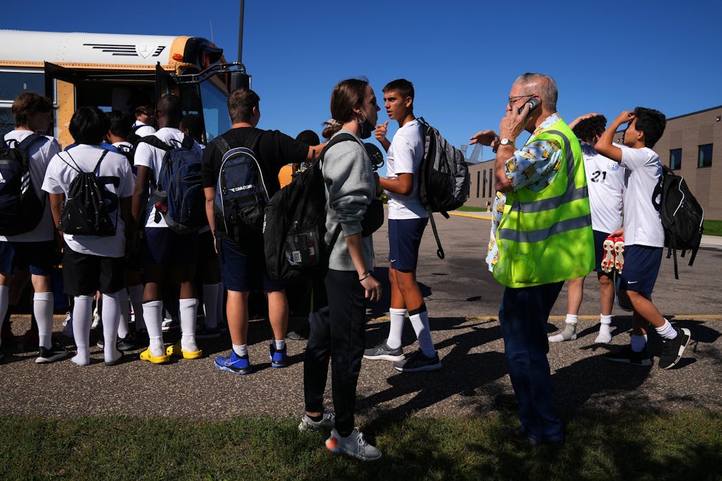 Bus driver Axel Gessell spoke on the phone to his bus company as the Blaine boys’ and girls’ freshmen soccer teams boarded the same bus to go to two different schools for away matches.