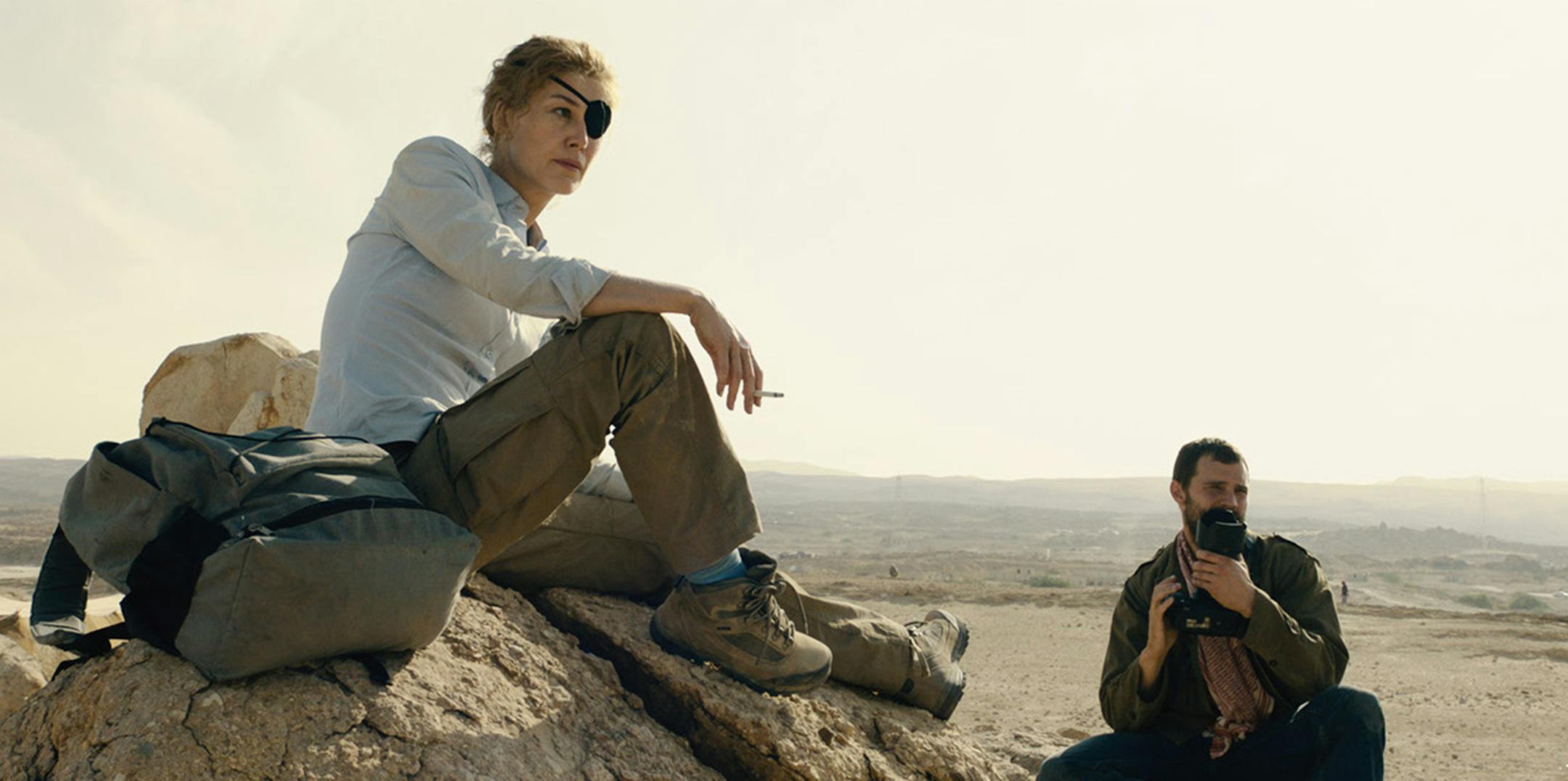 a private war: (L to R) Marie Colvin (Rosamund Pike) and Paul Conroy (Jamie Dornan) scout the arid landscape in A PRIVATE WAR.
Photo credit: Aviron Pictures