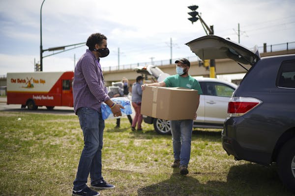 Fran Evenson, left, and Chris Knutson carried a load of water and blankets, respectively, for residents of the homeless encampment near the Sabo bridg