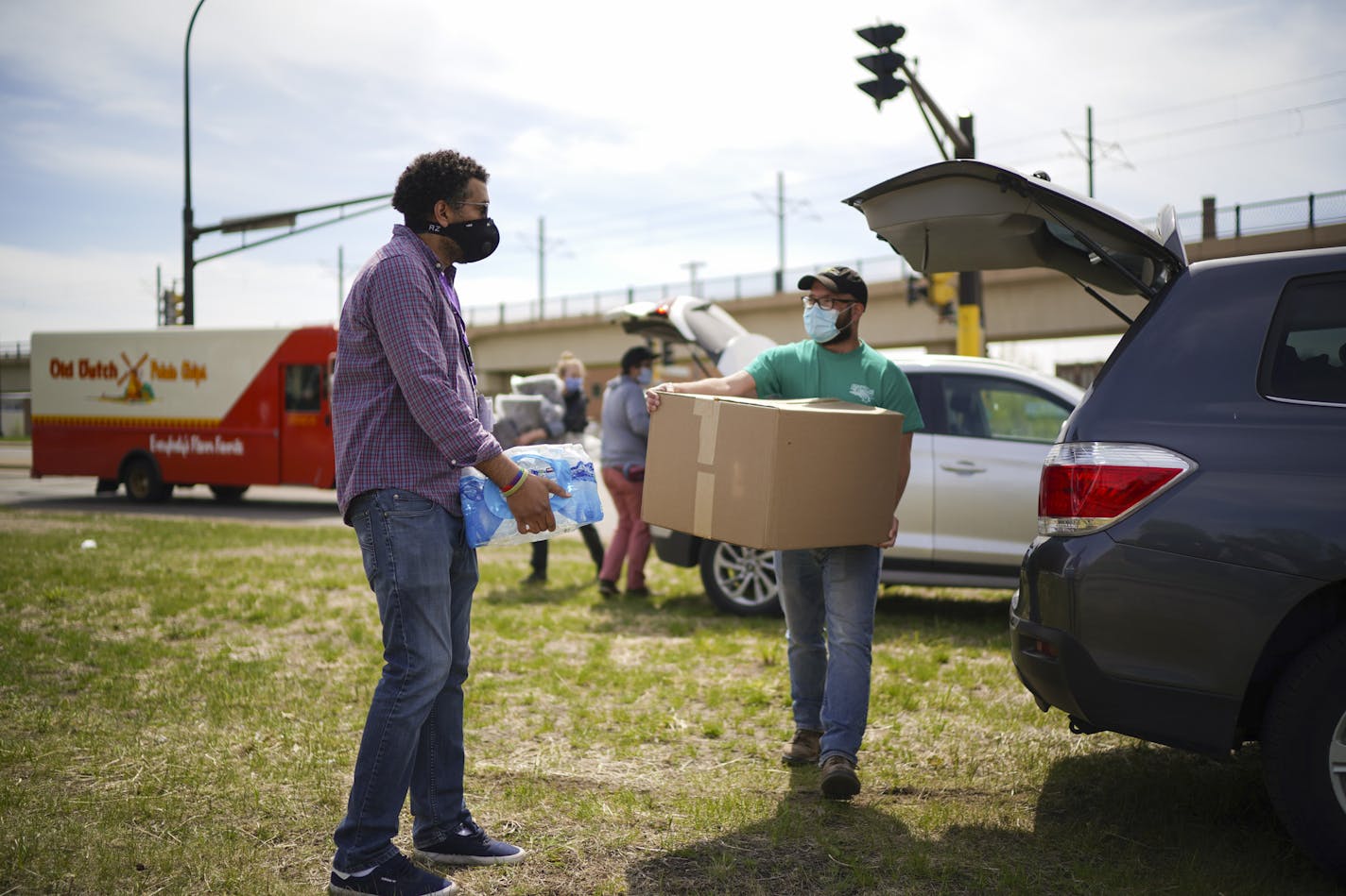 Fran Evenson, left, and Chris Knutson carried a load of water and blankets, respectively, for residents of the homeless encampment near the Sabo bridge Thursday afternoon. ] JEFF WHEELER • Jeff.Wheeler@startribune.com Chris Knutson and Fran Evenson are outreach workers with St. Stephens Human Services. They were photographed when they checked in on the homeless encampment near the Martin Olav Sabo Bridge bridge on Hiawatha Ave. Thursday afternoon, May 7, 2020 in Minneapolis. They delivered 100 l