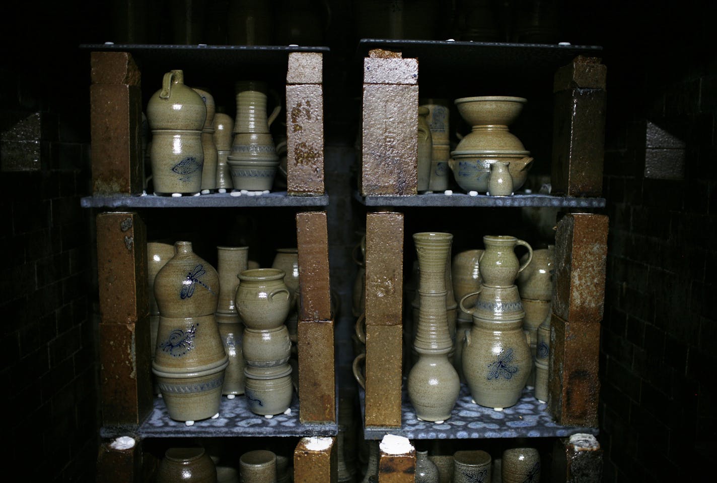 Red Wing Pottery, a 140-year-old business whose name is inextricably woven with the Mississippi River town, will cease to exist at the end of the year unless a buyer comes foward. IN THIS PHOTO: Salt glaze pottery stands in the kiln after being fired. The blue glaze patterns on the pottery are special, other colors of glaze don't work near as well at the blue. ] David Denney - Star Tribune ddenney@startribune.com 11/04/13 Red Wing, Mn