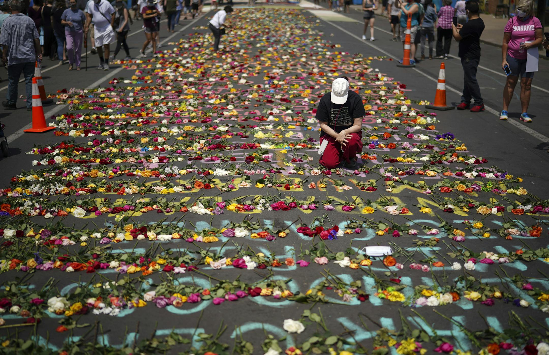 Visitors to the Minneapolis intersection where George Floyd was arrested left fresh flowers Sunday, June 7, on the names of other victims of police violence.