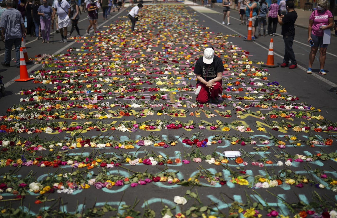 Visitors to the Minneapolis intersection where George Floyd was arrested left fresh flowers Sunday, June 7, on the names of other victims of police violence.