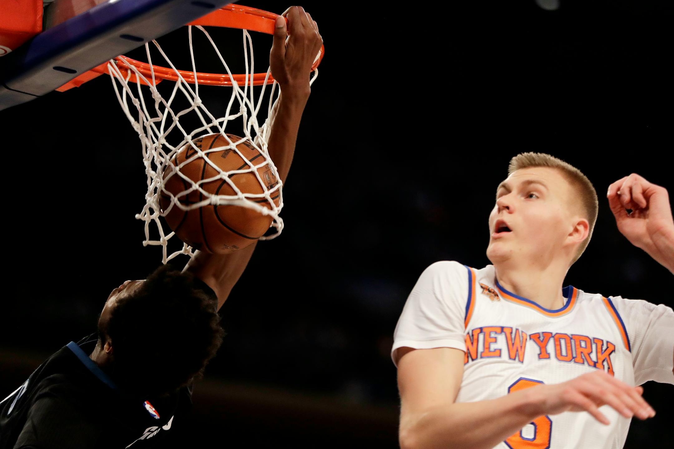 Minnesota Timberwolves forward Andrew Wiggins, left, dunks against New York Knicks forward Kristaps Porzingis during the first half of an NBA basketball game at Madison Square Garden in New York, Friday, Dec. 2, 2016. (AP Photo/Julio Cortez)