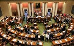 Representatives gather on the floor of the Minnesota House in the state Capitol in St. Paul, Minnesota, on Friday, May 24, 2019, on the opening day of