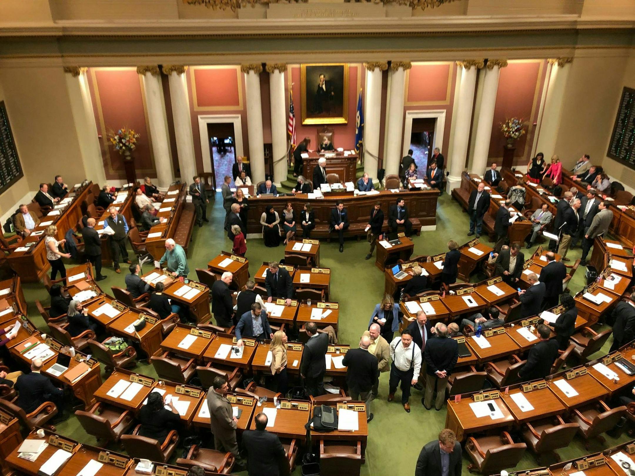 Representatives gather on the floor of the Minnesota House in the state Capitol in St. Paul, Minnesota, on Friday, May 24, 2019, on the opening day of a special session to finish work on the state's $48 billion two-year budget. (AP Photo/Steve Karnowski)
