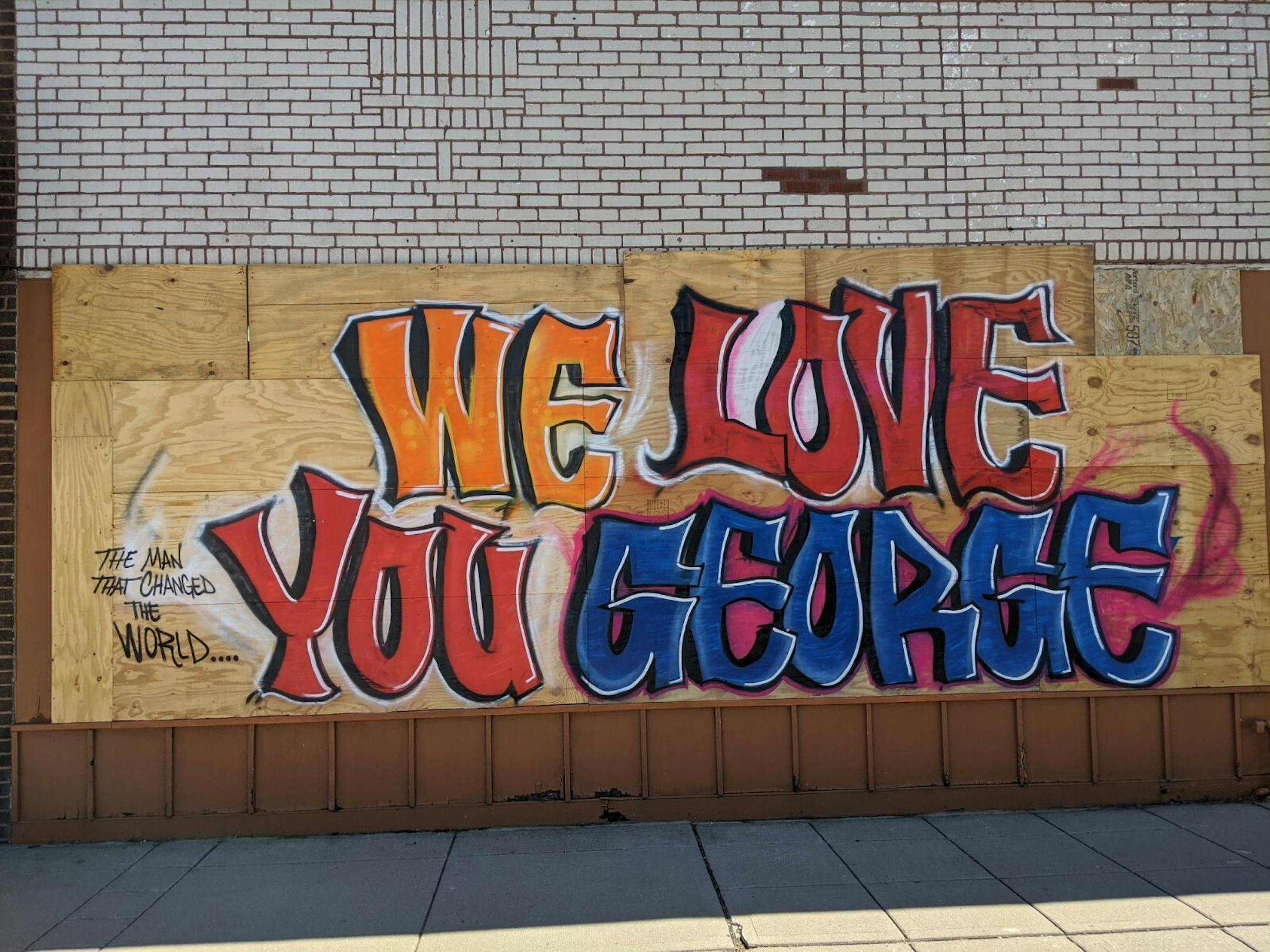 Artists lead with messages of love for George Floyd on a mural at Prairie Woodworking, 3535 E. Lake St.