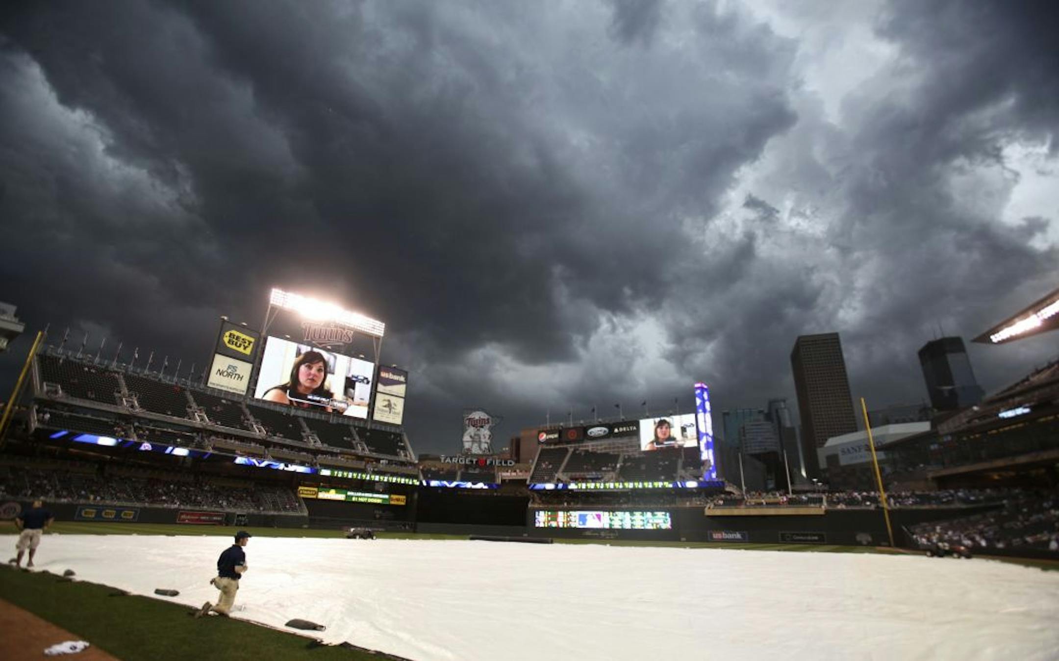 Twins Grounds crew try to keep the tarp in place as high winds and rain clouds rolled in over the ball park at Target Field in Minneapolis, Minn. Friday, July 1, 2011.