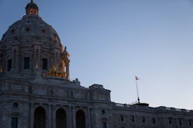 The sun rises over the horizon as the new Minnesota state flag flaps in the wind atop the Minnesota State Capitol in St. Paul on May 11.
