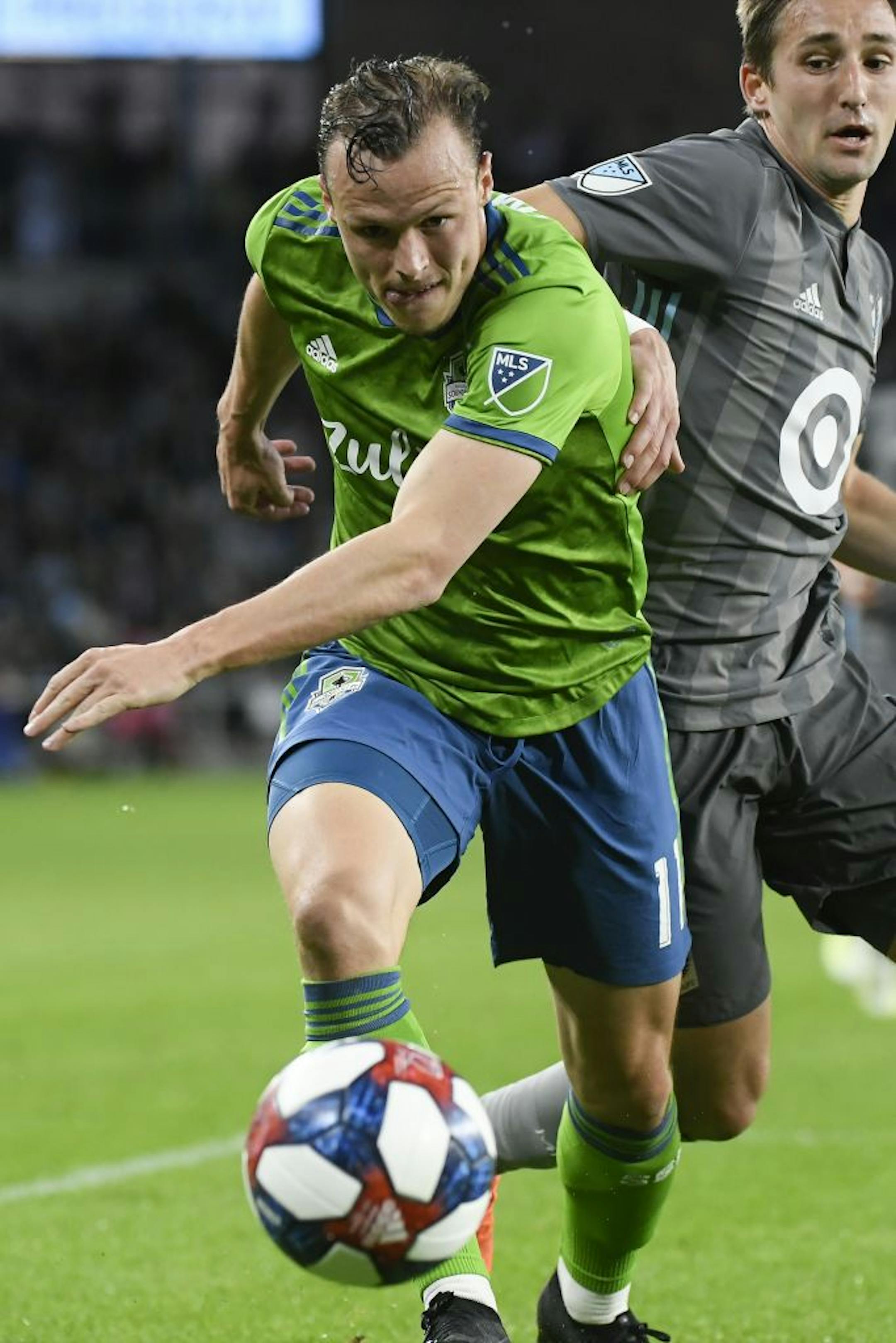 Seattle Sounders defender Brad Smith (11) and Minnesota United midfielder Ethan Finlay (13) chased down the ball near Seattle's goal in the second half.