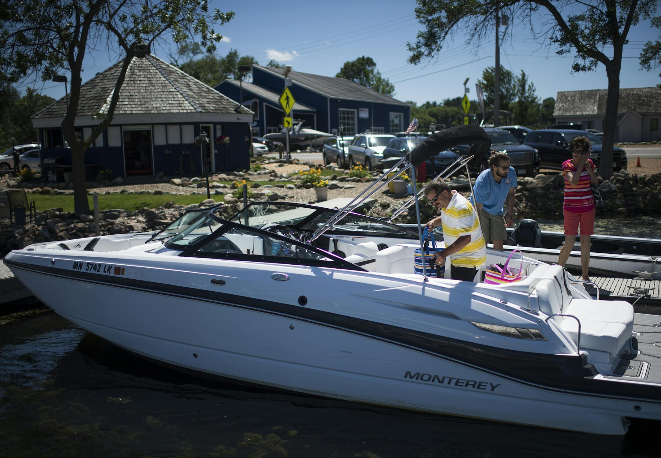Dennis, left, and Marlene Brandt were helped into a boat by Spencer Larson before they took to Lake Minnetonka in their rented boat.