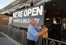 Greg Thomas picks up his lunch from Samantha Madec at Lure Fish House on South California Street in downtown Ventura, Calif. on Wednesday, April 22, 2