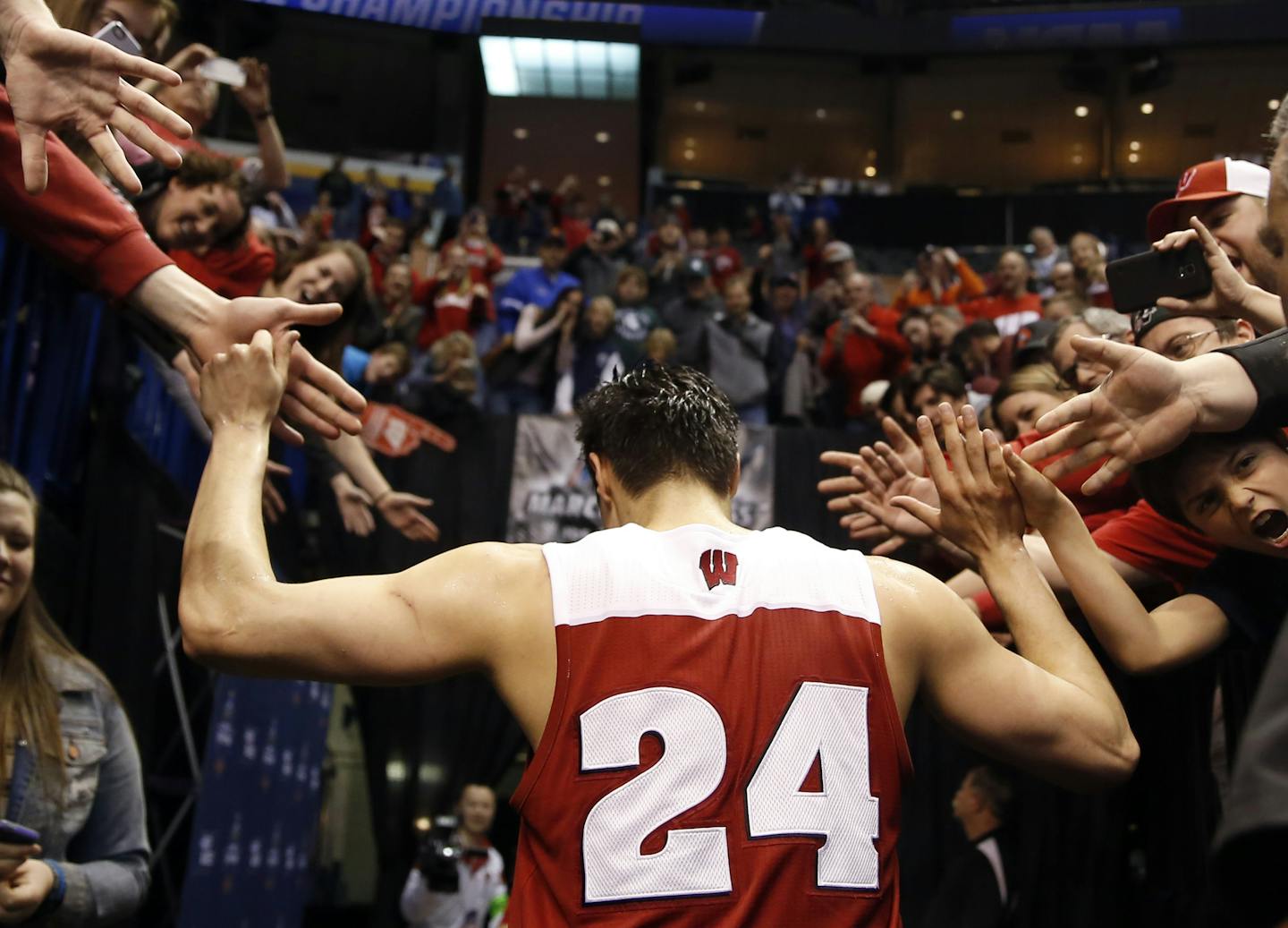 Wisconsin's Bronson Koenig is congratulated by fans as he leaves the court after hitting a three-point basket at the buzzer to defeat Xavier in a second-round men's college basketball game in the NCAA Tournament, Sunday, March 20, 2016, in St. Louis. Wisconsin won 66-63.