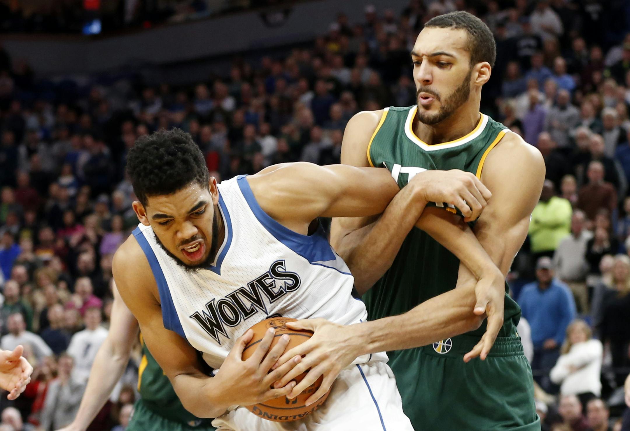 Minnesota Timberwolves' Karl-Anthony Towns, left, and Utah Jazz's Rudy Gobert, of France, get tied up in a battle for the ball during the second half of an NBA basketball game Saturday, Jan. 7, 2017, in Minneapolis. A jump ball was called on the play. (AP Photo/Jim Mone)