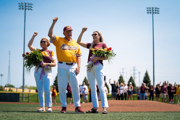 Gophers baseball coach John Anderson, center, accompanied by wife, Jan, and daughter, Erin, chant the “Rouser” at Anderson’s retirement celebrat