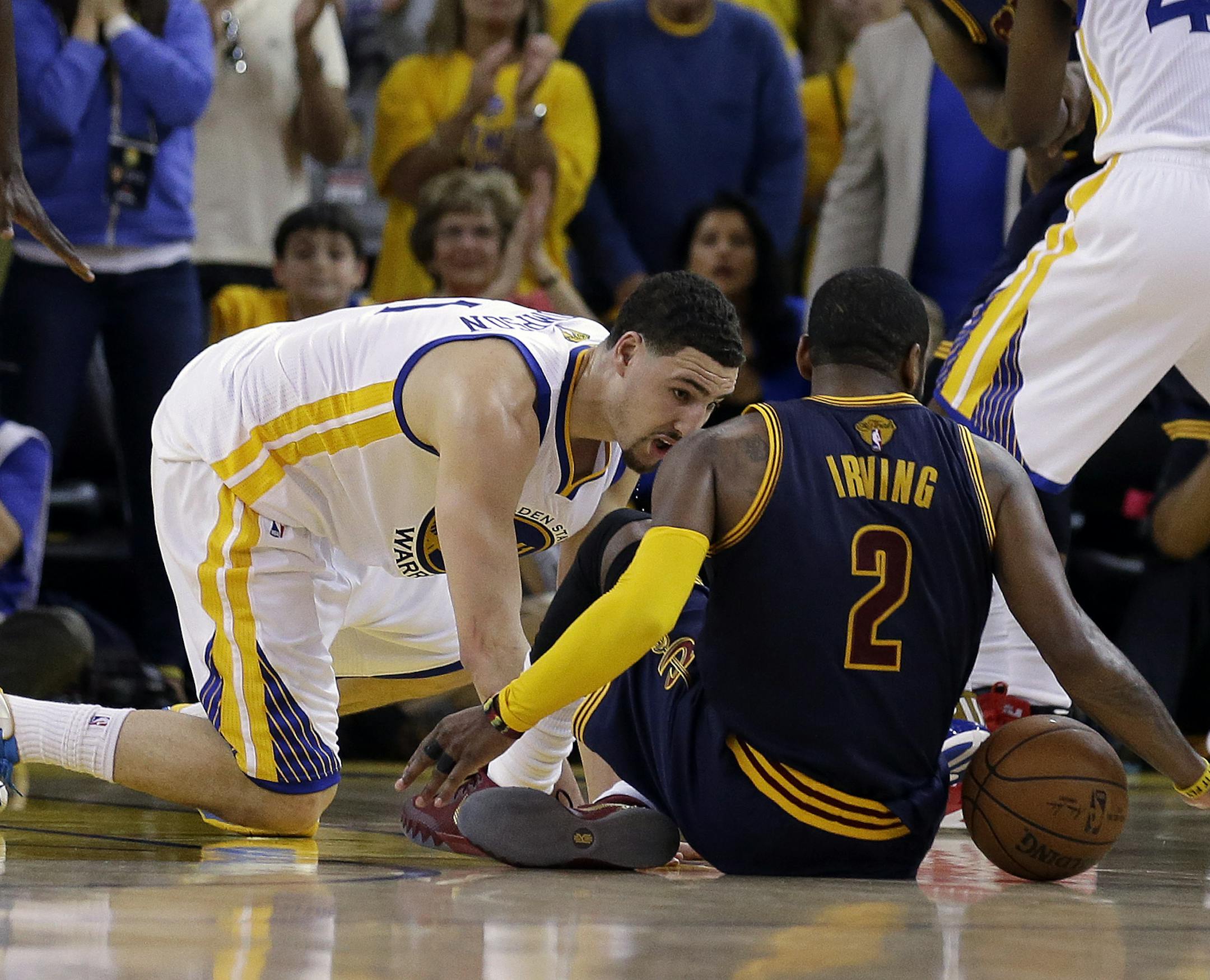 Cleveland Cavaliers guard Kyrie Irving (2) tries to control the ball next to Golden State Warriors guard Klay Thompson during overtime of Game 1 of basketball's NBA Finals in Oakland, Calif., Thursday, June 4, 2015. Irving left the game with an injury right after this play. (AP Photo/Ben Margot)
