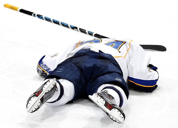 St. Louis Blues T.J. Oshie (74) lay on the ice after a hit in the second period.