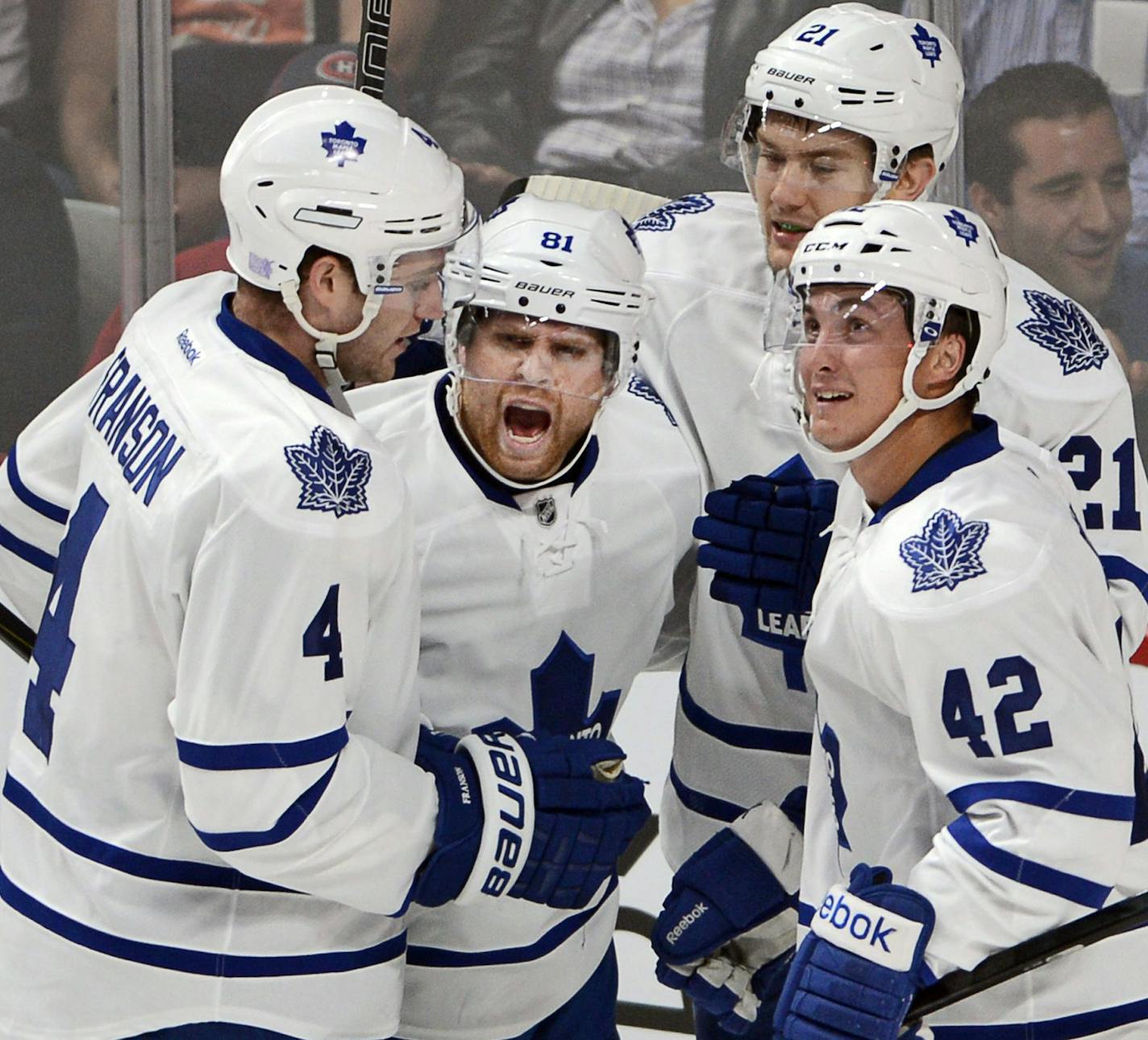 Toronto Maple Leafs left wing James van Riemsdyk (21) celebrates with teammates Cody Franson (4), Phil Kessel (81) and Tyler Bozak (42) after van Riemsdyk scored a goal against the Montreal Canadiens during first period of an NHL hockey game on Tuesday, Oct. 1, 2013, in Montreal. (AP Photo/The Canadian Press, Ryan Remiorz)