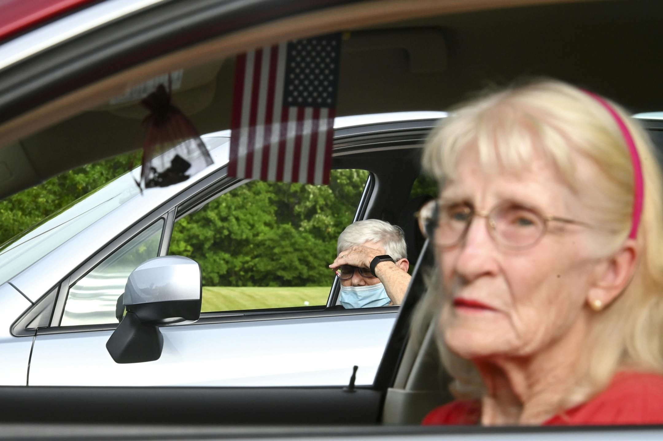 Kaye Sauer, 88, back, of Maplewood, prayed in her car during Transformation Church's evening mass Wednesday. Sauer says she's been coming to the church for 50 years, but due to recent health issues, she's been attending mass in her car or virtually. "We'll go with the flow" she said of her church's evolving circumstances with the pandemic. To the right is Barbara Houle, of Oakdale, who says she'd rather be in church but the parking lot service is "the next best thing" given the circumstances.
