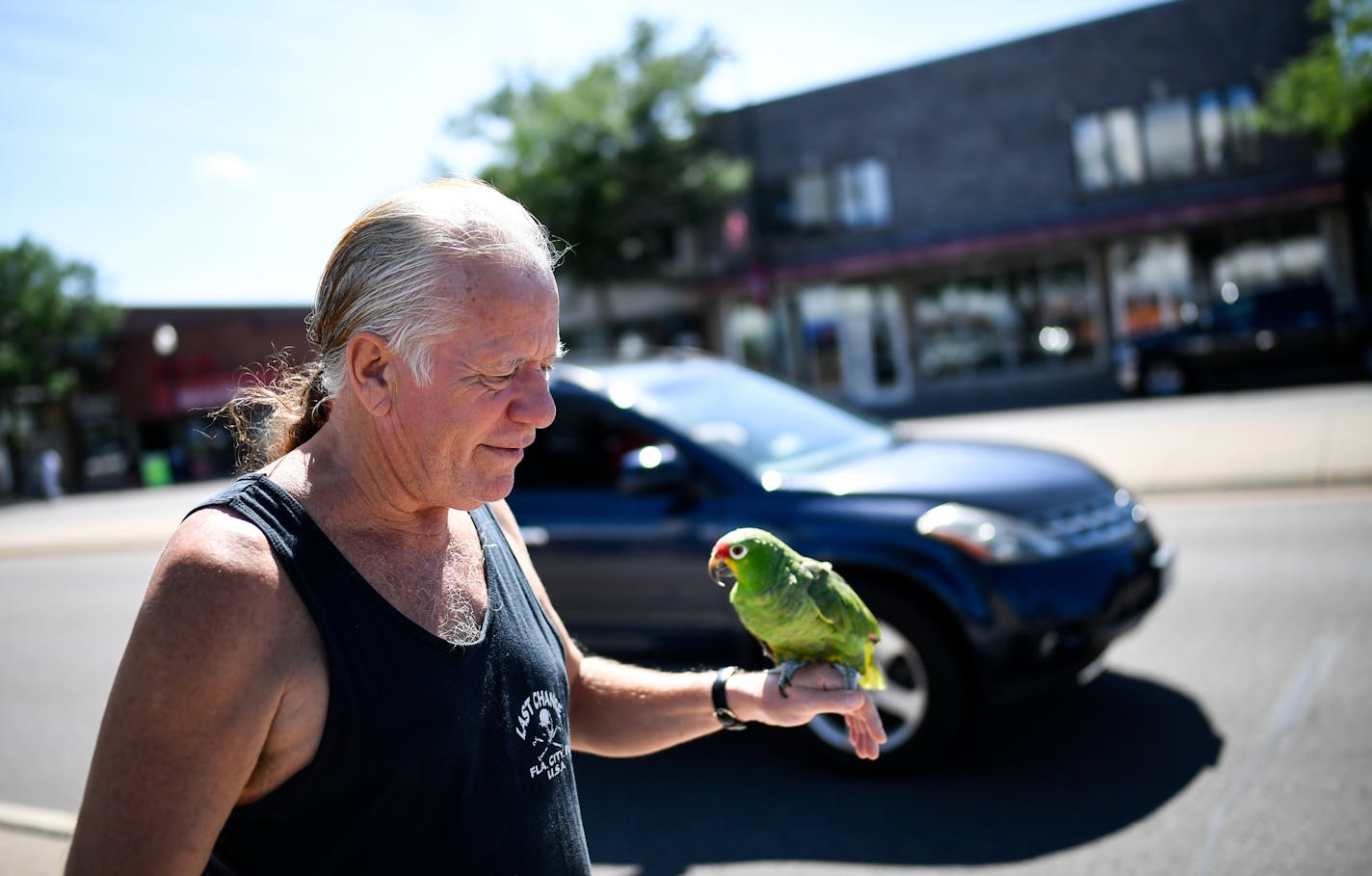 Ken Bourke, 64, walked along Central Avenue in Columbia Heights last week with Scooter, his 27-year-old red-lored amazon parrot. Central Avenue is a key corridor through the inner-ring suburb, but city leaders know the area needs some major sprucing up.