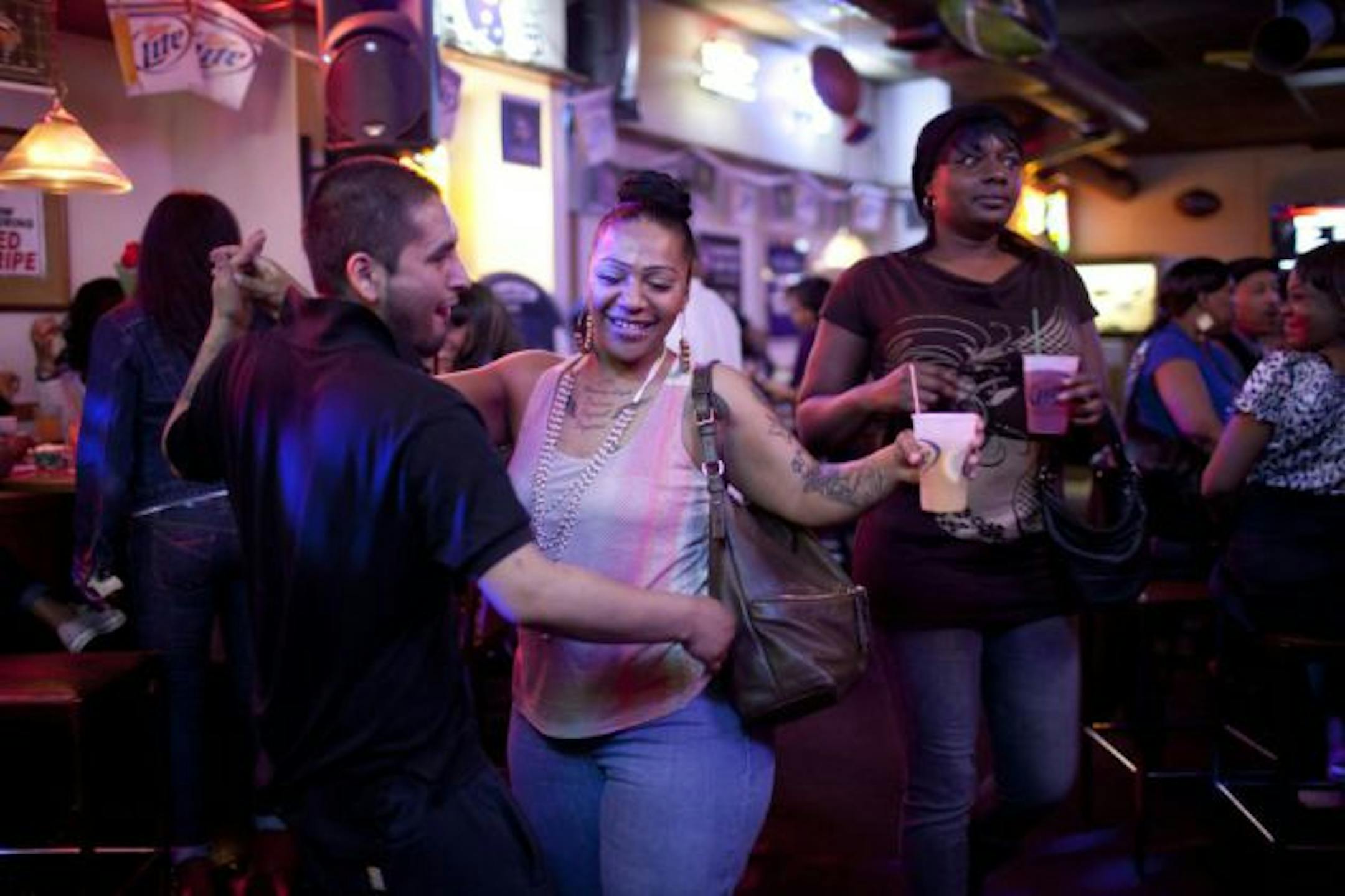 Champions bar in south Minneapolis is a neighborhood mainstay, a rough dive with a band of loyal customers. This week 14 people were arrested on drug charges following an undercover police operation that shed light on the bar's continuing challenges. On Friday, liquor license officials will meet with the bar to discuss the issues. Carlos Pinos and Crystal Collins, both of Minneapolis, danced together at Champions Bar in Minneapolis, Minn. late Wednesday night, March 21, 2012.  ] JEFF WHEELER • jeff.wheeler@startribune.com