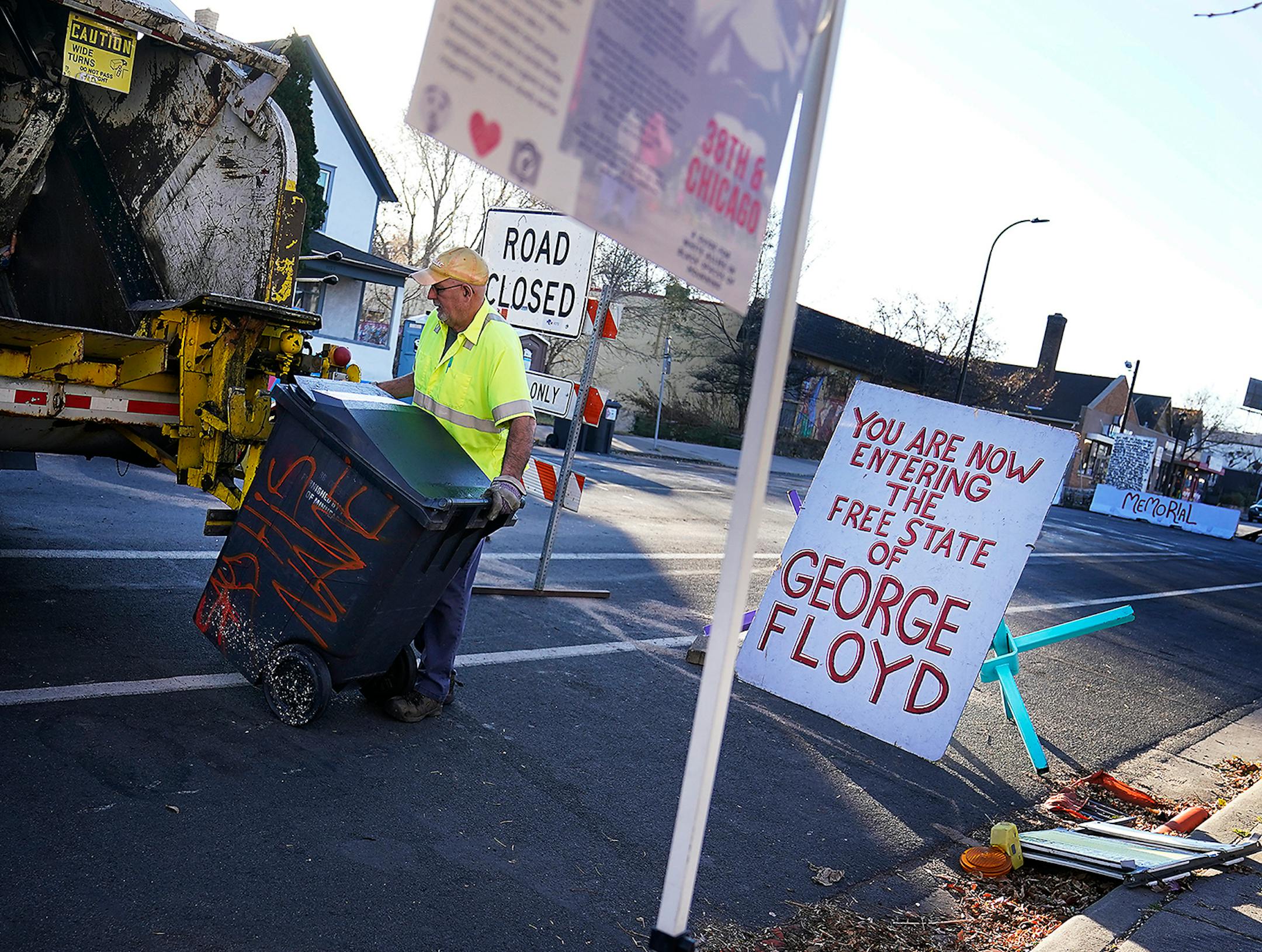 A garbage collector empties a refuse container at George Floyd Square along Chicago Avenue and seen Wednesday in Minneapolis.