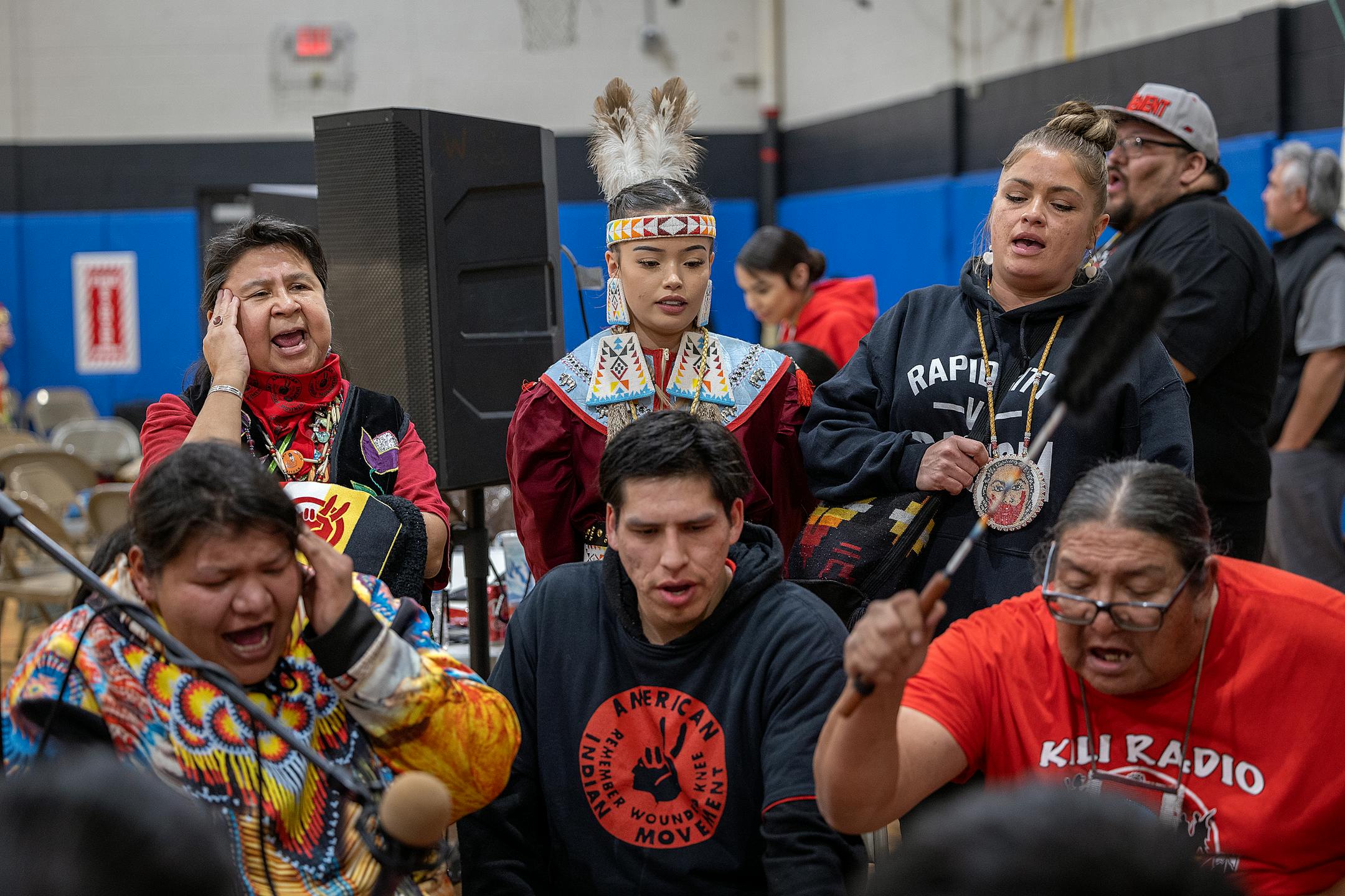 AIM Minnesota director Lisa Bellanger, left, joins in to sing along with the drummers during a Pow Wow to honor the 50th Anniversary of the AIM Warriors of Wounded Knee of 1973 in Rapid City, SD.