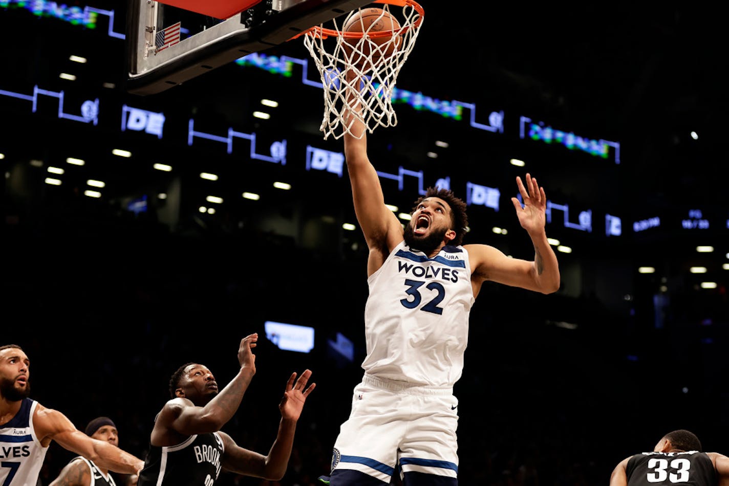 Minnesota Timberwolves center Karl-Anthony Towns (32) drives to the basket past Brooklyn Nets center Nic Claxton during the first half of an NBA basketball game, Tuesday, April 4, 2023, in New York. (AP Photo/Adam Hunger)