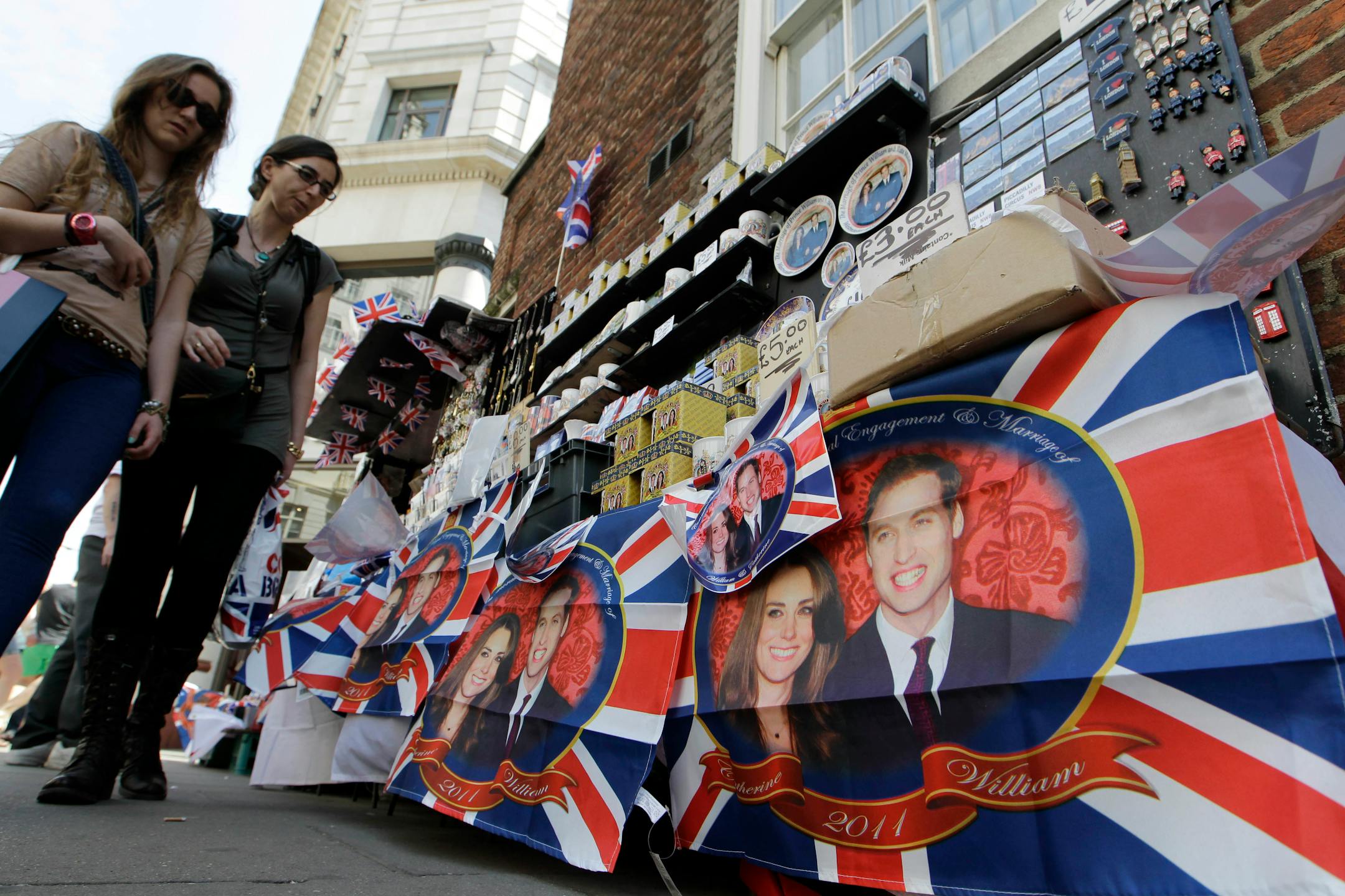 People look at soveniers of Prince William and Kate Middleton on display at a street stall in London