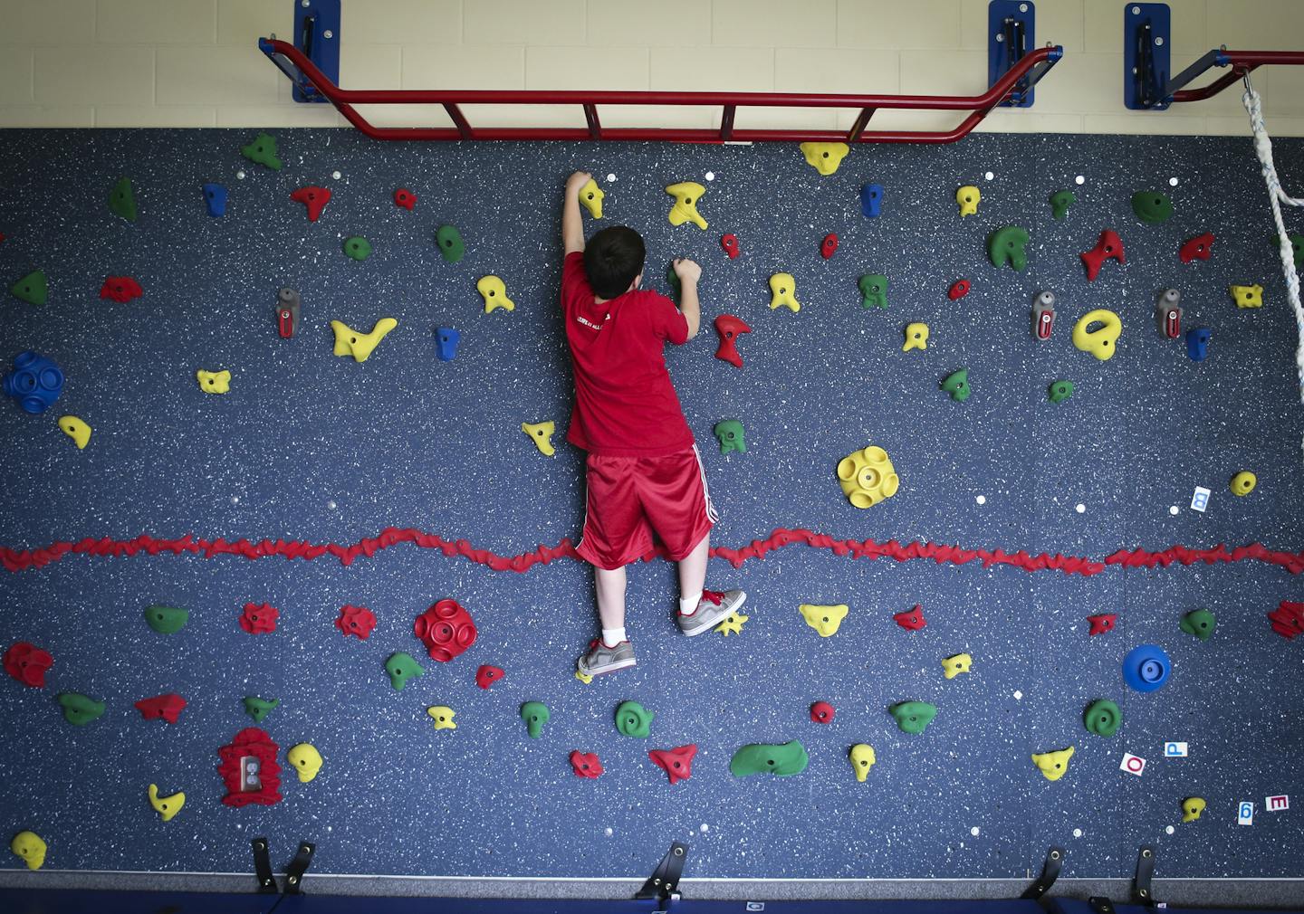 Tyler Hawley climbed the rock wall in the gym at Karner Blue school in Blaine.