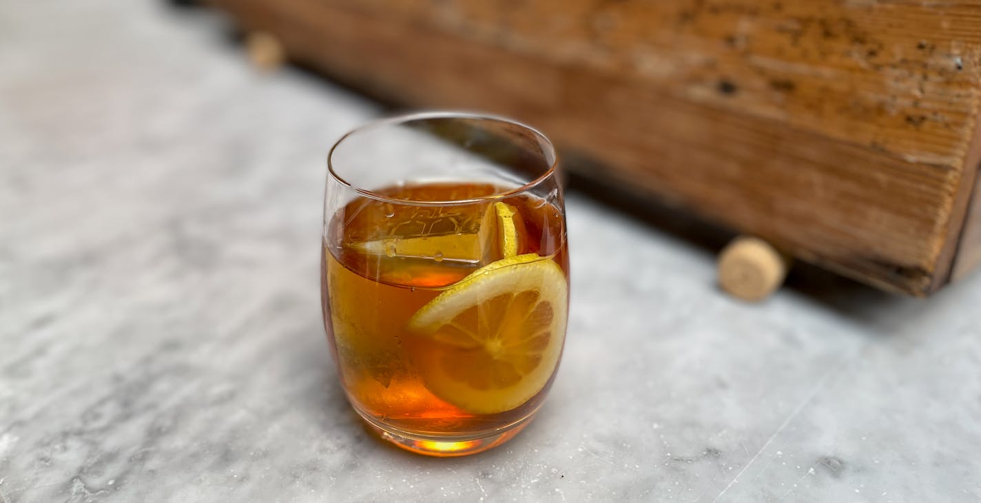 Peach tea negroni at Spoon and Stable with ice that says, "Taste the City."