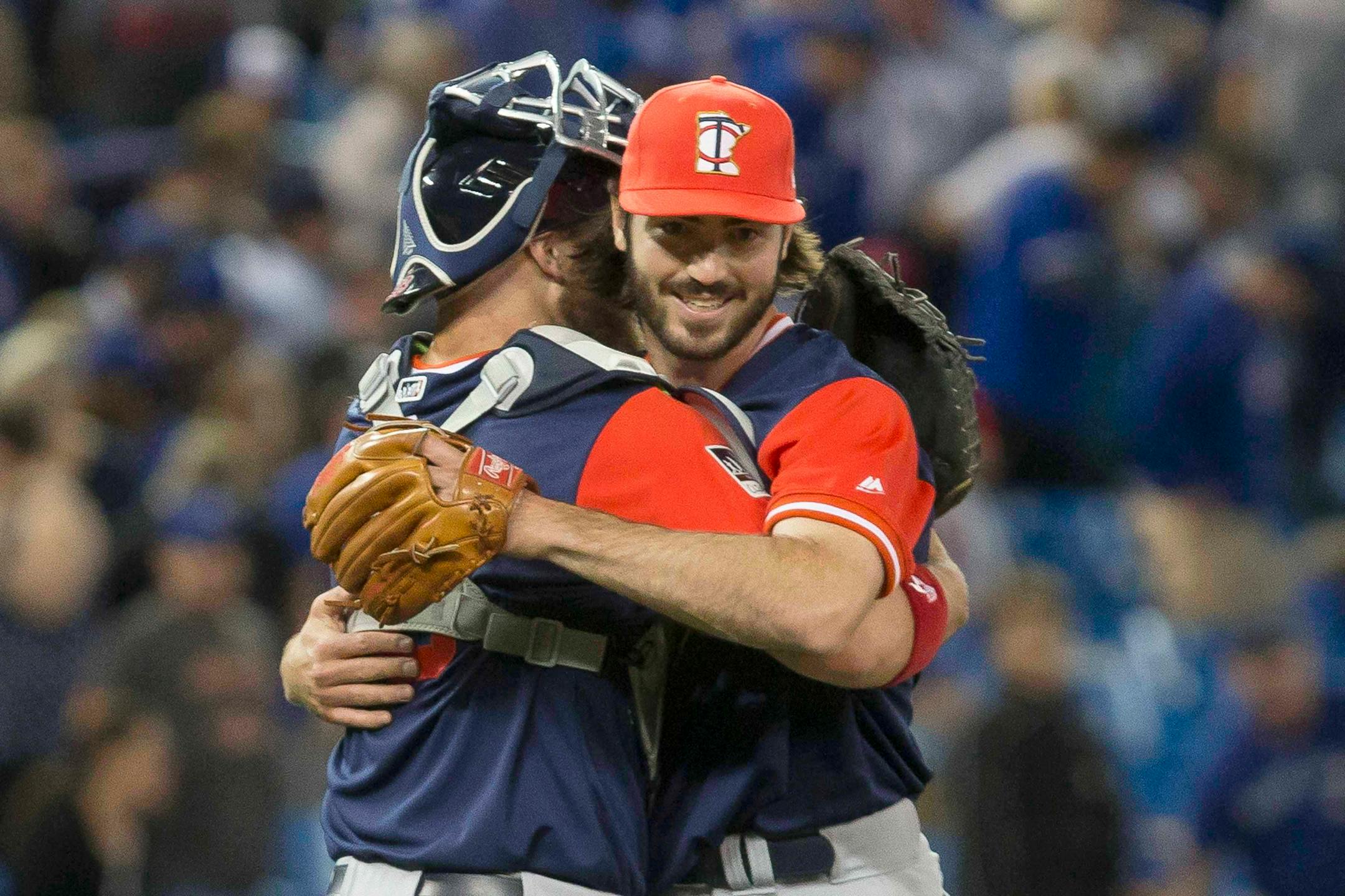 Minnesota Twins relief pitcher John Curtiss, right, celebrates with catcher Chris Gimenez after the Twins defeated the Toronto Blue Jays in a baseball game Friday, Aug. 25, 2017, in Toronto. (Chris Young/The Canadian Press via AP)