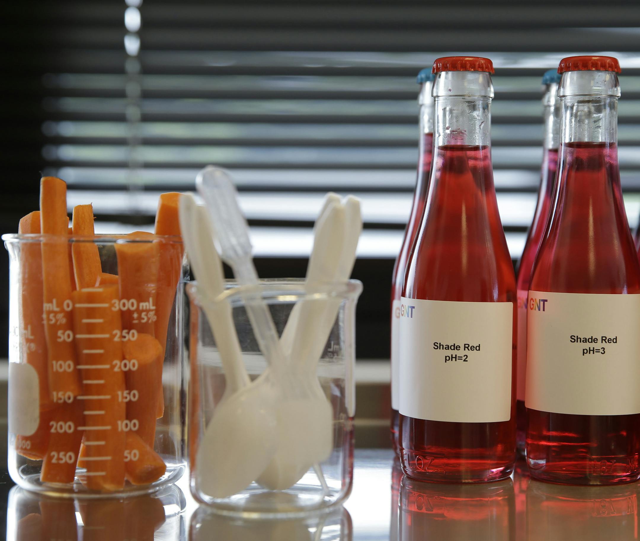 In this photo from July 29, 2015, bottles of liquid colored with plant-based natural colors, some from carrots, are displayed at the offices of GNT in Tarrytown, N.Y. Several major food makers are hoping to win over customers by vowing to rid their products of artificial ingredients. But replicating the vivid colors Americans have to expect without synthetic dyes presents technical and regulatory challenges, and in some cases will mean new hues for popular products. (AP Photo/Seth Wenig)
