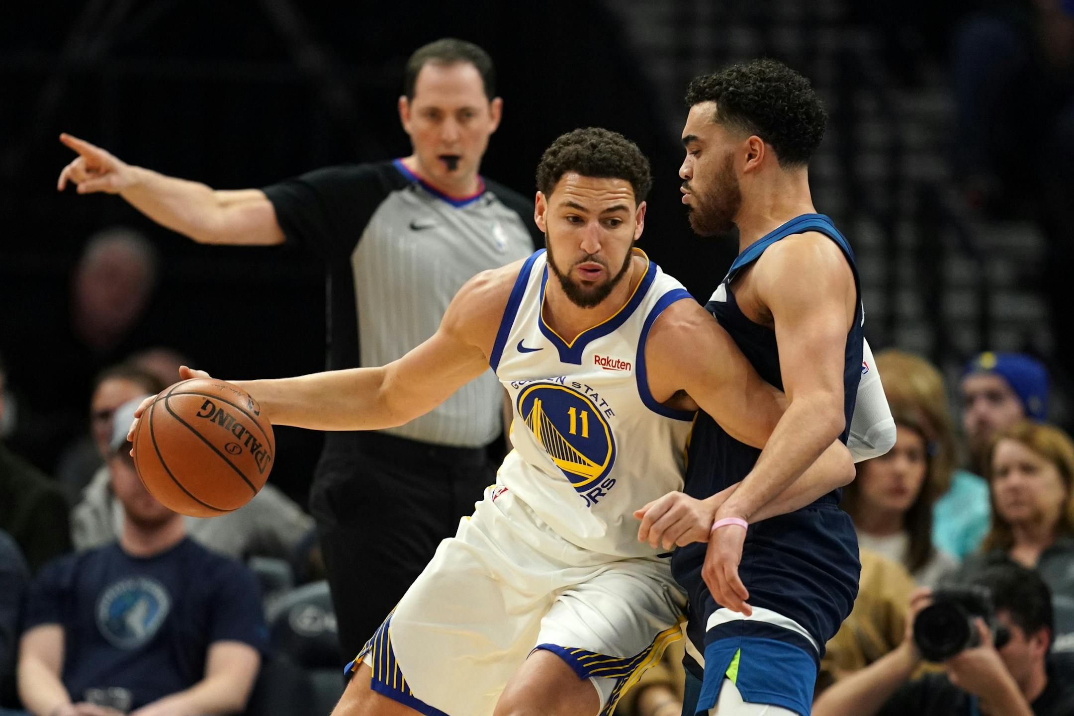 Golden State Warriors guard Klay Thompson (11) collided with Minnesota Timberwolves guard Tyus Jones (1) as he drove to the basket in the first half.