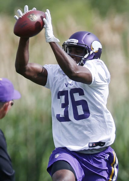 Minnesota Vikings head coach Mike Zimmer gets a close look at rookie cornerback Tre Roberson who pulls in a pass during defensive drills in the NFL fo