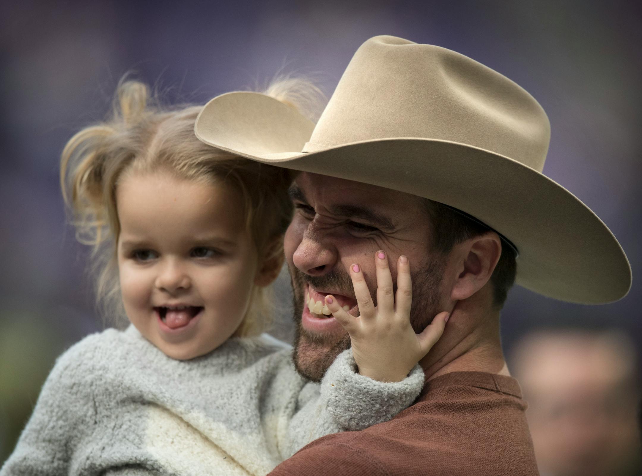 Former Viking Jared Allen with daughter Brinley, talks with former teammates on the sidelines.